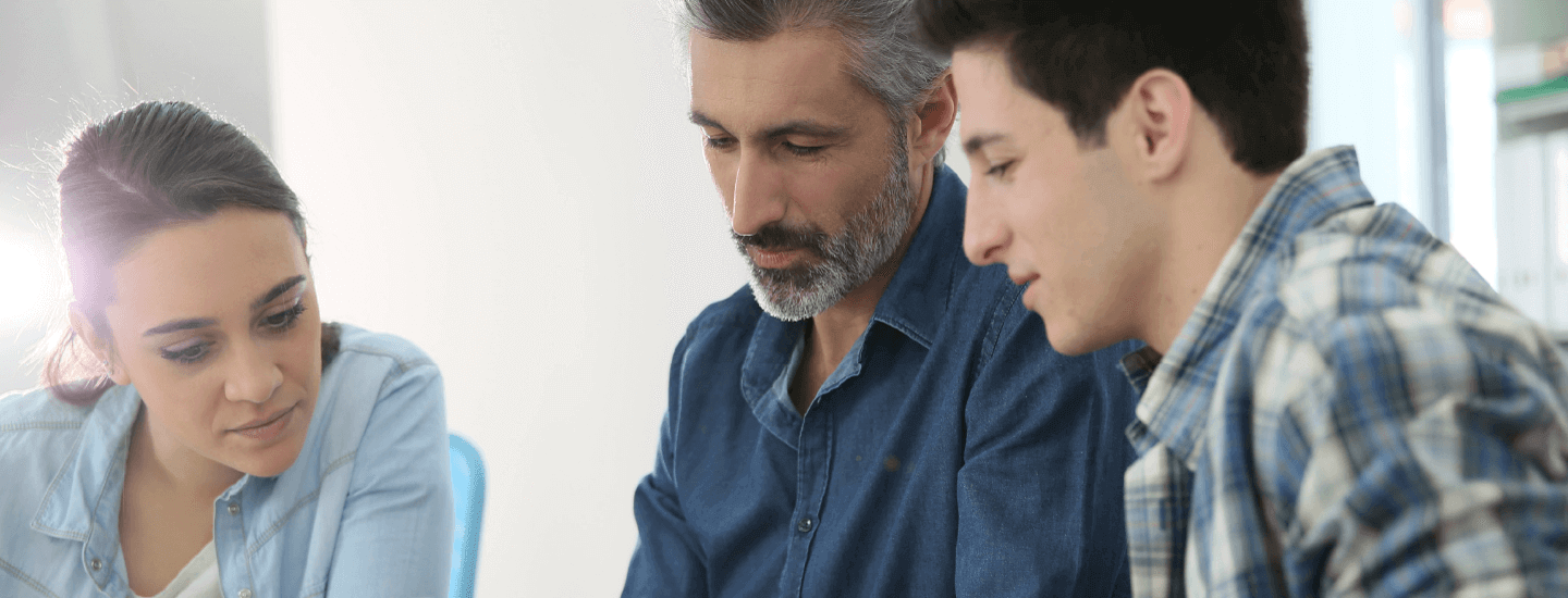 photo of three people sitting and discussing something in a professional setting